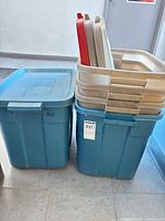 Two blue tote bottoms, stack of beige and red lids
