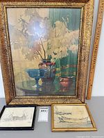 Group shot of three framed artworks with ruler for scale