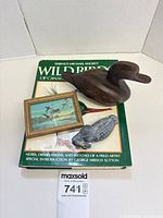 Group shot showing book, wooden duck, framed print, stone bird figurine