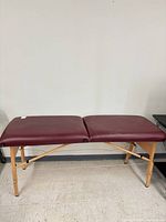 Massage table fully assembled, burgundy top, wood frame