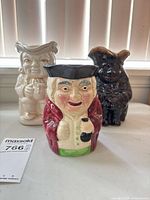 Front view of three ceramic toby jugs together
