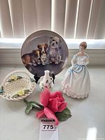 Group view of figurine, plate, basket, vase, rose