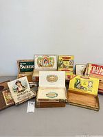 Group shot of all 13 vintage cigar boxes, lids open on two to show interiors