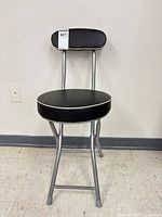 Stool unfolded showing seat, backrest, and frame
