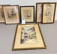 Six framed artworks—watercolor, lithograph, and four etchings displayed together