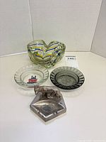 Group shot of glass swirl bowl, two glass ashtrays and metal ashtray