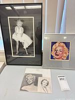Overview of both framed Marilyn portraits with unframed prints on table