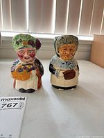 Both ceramic character pitchers side by side