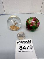 All three glass paperweights displayed together