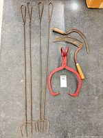 Full lot showing 4 grill stakes, 2 sickles, red ice tongs