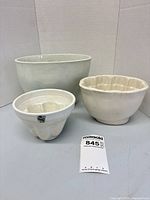 Front view of three graduated white/cream jelly molds