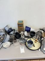 Overall view of assorted enamelware and utensils on table