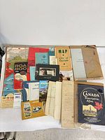 Overview of assorted maps, booklets, certificates and documents laid out on table