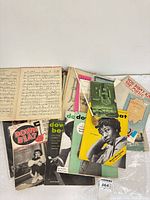 Pile view showing Down Beat magazines, multiple sheet music booklets and conductor’s baton