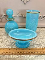 Front view of three Avon seafoam opaline glass pieces showing shapes and gold rims