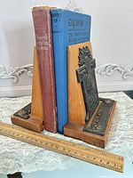 Pair of bookends holding books with ruler for scale