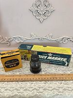 Price marker box, Waterman’s box, clear bottle shown with ruler for scale