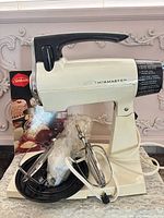 Full view of mixer with beaters, cord, and booklet