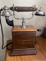 Front view showing oak case, handset cradle, and gold lettering