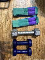 All items laid out: two ankle weights, 5 lb dumbbell, two 3 lb dumbbells