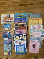 Single image showing front covers of all 20 children’s books laid out on floor