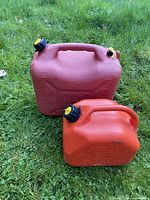 Front and top view of both red gas cans showing handles and caps