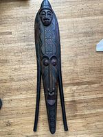 Front view of entire carved wood mask showing design and length