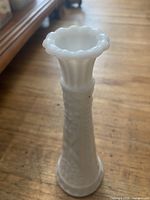 Milk glass bud vase profile view showing pattern and scalloped rim