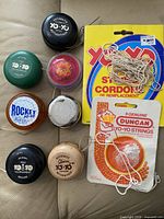 Seven yo-yos with two string packs displayed