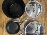 Interior view of deep pot, small fry pan and two stainless lids