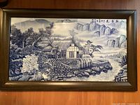 full view of framed blue-and-white ceramic landscape panel