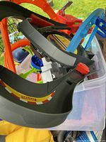 Assorted black, grey and orange curved track pieces inside clear tote