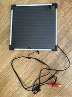 Front view of Coleman 7 W solar panel and attached cables