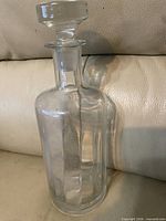 Full view of clear crystal decanter standing upright with stopper inserted