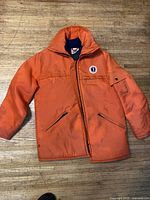 Full view of orange Mustang floater jacket front side