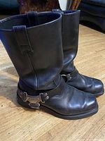 Side profile of both boots showing leather upper, harness strap and buckle