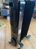 Oblique view of heater showing front control panel, power cord wrap and casters