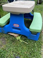 Blue and green Little Tikes plastic picnic table on grass
