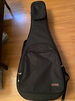 Full view of Odyssey acoustic guitar gig bag front showing pockets and logo