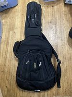 Full view of black Ritter padded electric guitar gig bag on floor
