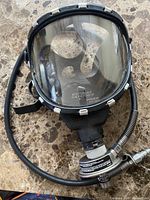 Full view of Scott Safety full-face respirator mask with attached hose and regulator