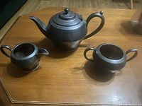 Overall view of teapot, sugar bowl and creamer on table