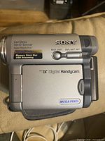 Left side showing Carl Zeiss lens branding, Mega Pixel, Memory Stick slot, Digital Handycam logo