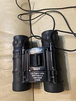 Front view showing Tasco logo, 8x21 specs and folding bridge