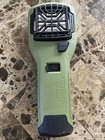 Front view of olive green Thermacell MR300 mosquito repeller with black grill and controls visible