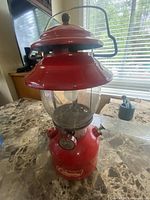 Angled left front view showing full lantern, bail handle, ventilator, globe and tank