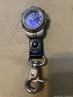 Front view showing dial, bezel, leather strap and lobster clasp