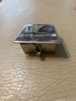 Closed pill box showing abalone lid and clasp