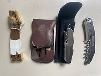 All items lined up: spoon bundle, Picnic Set pouch, Aroma multi-tool with sheath, folding corkscrew