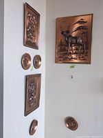 Overall view of plaque set on walls showing deer plaque, two rectangular florals, three round medallions